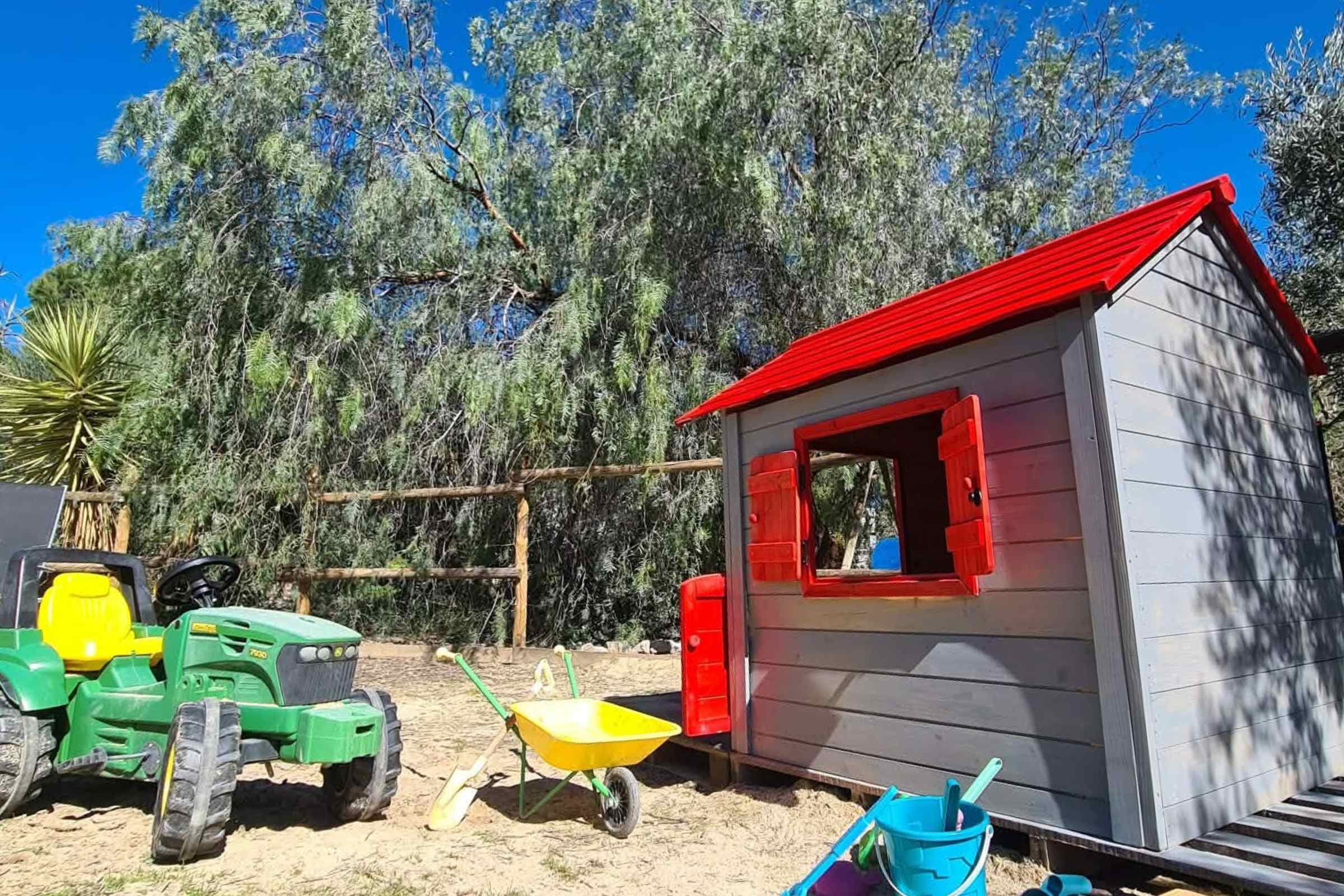Kids can play freely in the sand area with toys and wendy house.